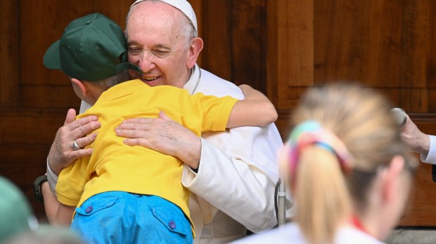Papa Francisco abraça uma criança