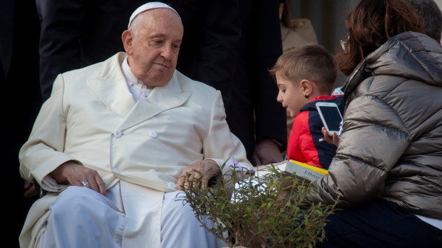 Pope Francis blesses a child at the end of his weekly general audience in Saint Peter's square at the Vatican